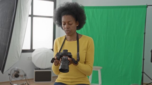 Woman holding camera with hand to forehead in studio with green screen and softbox lights; frustration doubt.