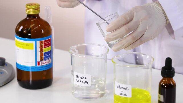A close up video of a scientist mixing starch in a beaker with water and hydrogen peroxide solution.