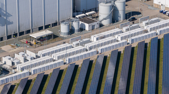 Lelystad, Netherlands - 21 April 2026: Aerial view of the Maxima plant power station and offshore wind turbines along the coast under a clear blue sky.