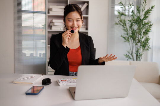 Asian businesswoman providing customer service with headset and laptop