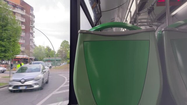 Public Transport Journey: Captured from the interior of a bus, this image offers a glimpse into urban life, as a modern car navigates city streets. 