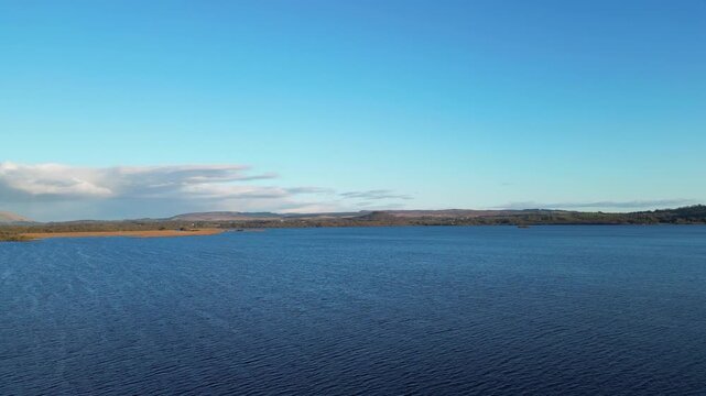 Aerial View of Calm Water of Massive Lake at Balmaha Valley Village Near Glasgow Landscape During Sunset. Village is a popular tourist destination for picnickers and day trippers from Glasgow