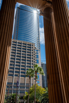 Columns of the State Library with modern glass building behind with a starburst