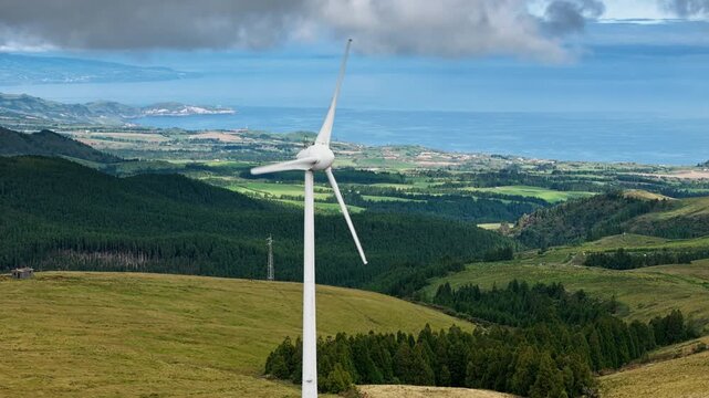 Renewable wind energy on Sao Miguel Island with rolling green hills and forests. Sustainable power generation in Azores region