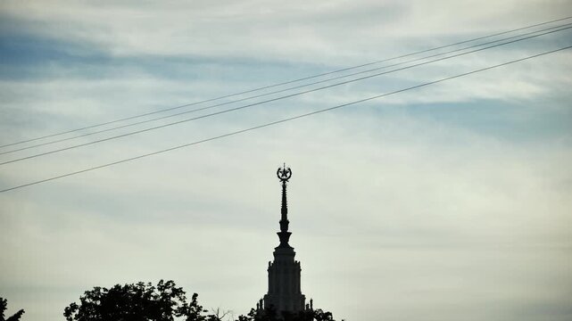 Man silhouetted ziplining across Moscow sky with Moscow State University spire