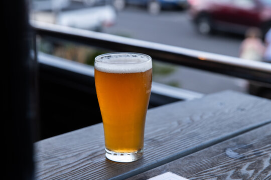 cool glass of beer with condensation sitting on an outdoor table