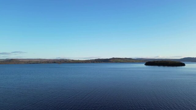 Aerial View of Calm Water of Massive Lake at Balmaha Valley Village Near Glasgow Landscape During Sunset. Village is a popular tourist destination for picnickers and day trippers from Glasgow