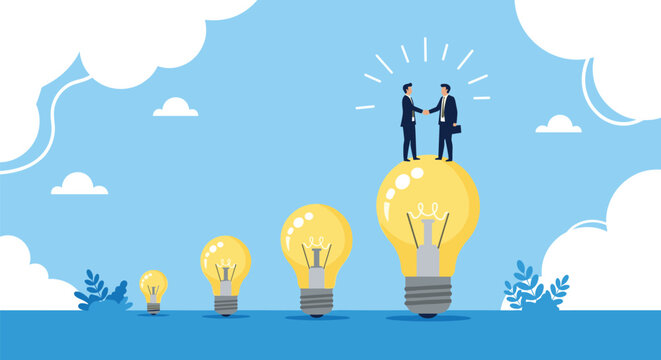 Two business partners shake hands while standing on top of a giant glowing lightbulb symbolizing a successful and bright idea.