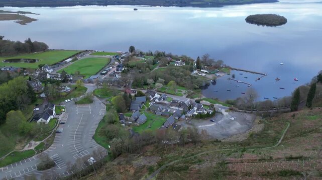 Aerial View of Calm Water of Massive Lake at Balmaha Valley Village Near Glasgow Landscape During Sunset. Village is a popular tourist destination for picnickers and day trippers from Glasgow