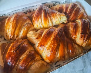 Fototapeten Brot Golden Butter Croissants in a Bakery Box. A collection of six freshly baked, golden-brown croissants rests inside a white pastry box.  © Andi