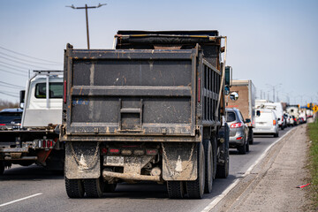 Rear view of dump truck in traffic on road. © Erman Gunes