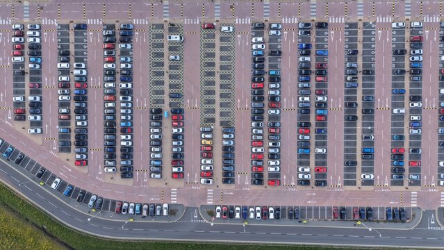 Birmingham, United Kingdom - 21 April 2026: Aerial view of the Amazon EMA4/UXD1 parking lot with rows of colorful cars parked in organized bays and road markings.