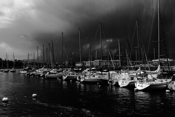 Bateaux de plaisance et voiliers amarrés dans le port de Genève sous un noir ciel d'orage © PPJ
