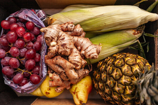 Ginger, grapes, pineapple and corn in box at fresh food hub