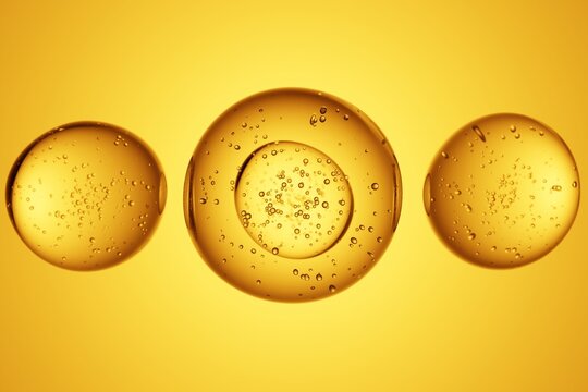 Golden oil bubbles on yellow background, macro texture