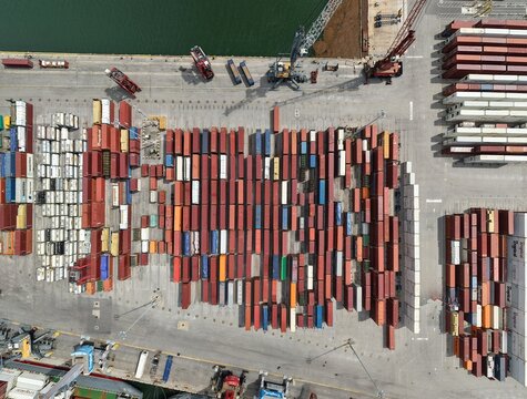 Riviera Beach, United States - 15 April 2026: Aerial view of a shipping container terminal with rows of colorful cargo containers and port cranes.
