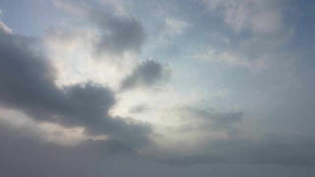 Ethereal mountain summits emerge from a sea of morning mist under a luminous sky