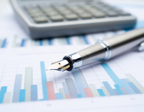 Macro shot of fountain pen on financial report with liquidity and leverage charts
