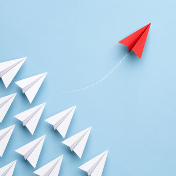 Avion en papier rouge sortant du groupe sur fond bleu minimaliste
