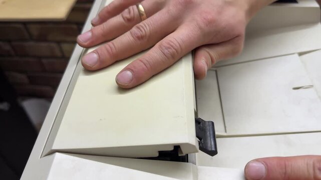 Hands opening and closing the top cover of a home or office printer. Close up of operating printer lid for maintenance or paper access. Everyday office equipment use and document printing concept