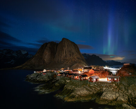Northern lights shine over rorbuer cabins in Norway's Lofoten Islands