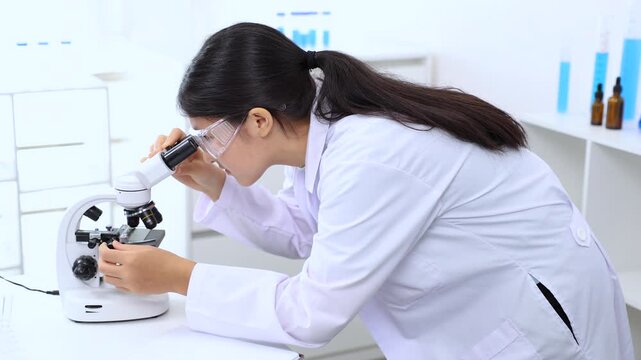 Teen girl observing a sample under the microscope during experiment. Science, laboratory, scientist, experiment, and research express hands-on learning and curiosity in a lab environment, healthcare.
