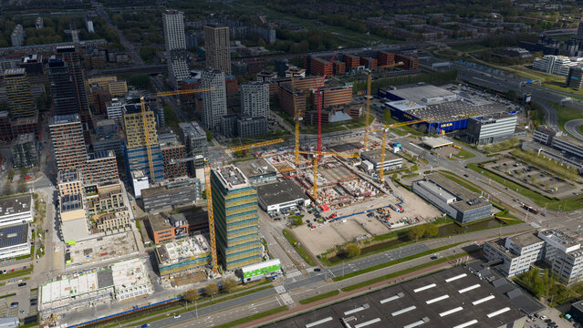 Amsterdam, Netherlands - 19 April 2026: Aerial view of the Bullewijk business district featuring active construction sites with cranes, modern skyscrapers, and the IKEA store under a clear sky.
