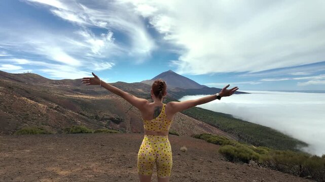 Athletic woman reaching the top of a mountain