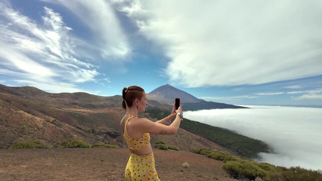 Young woman taking selfie on teide volcano mountain peak