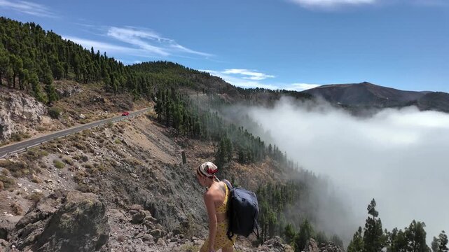 Adventurous woman exploring majestic mountains above clouds