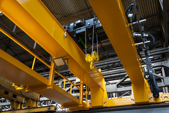 Low angle view of yellow overhead crane and hoist system in factory