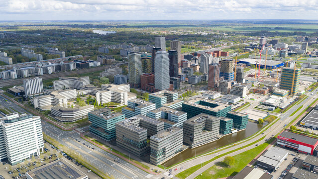 Amsterdam, Netherlands - 19 April 2026: Aerial view of Bullewijk business district with modern skyscrapers, office complexes, and construction cranes under a bright sky.