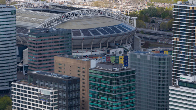 Amsterdam, Netherlands - 19 April 2026: Aerial view of Johan Cruijff Arena surrounded by modern office buildings and skyscrapers in the urban landscape.