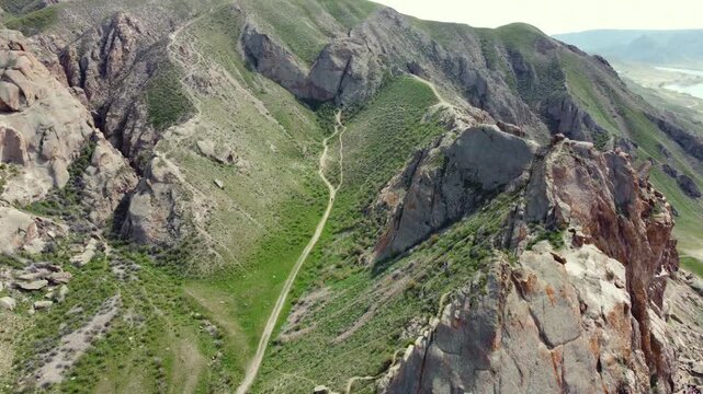 Aerial 4K view of Ili River and sacred Tamgaly Tas petroglyphs in Kazakhstan steppe
