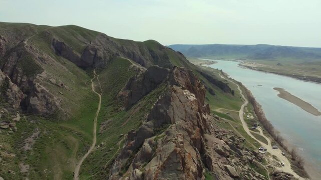 Aerial 4K view of Ili River and sacred Tamgaly Tas petroglyphs in Kazakhstan steppe