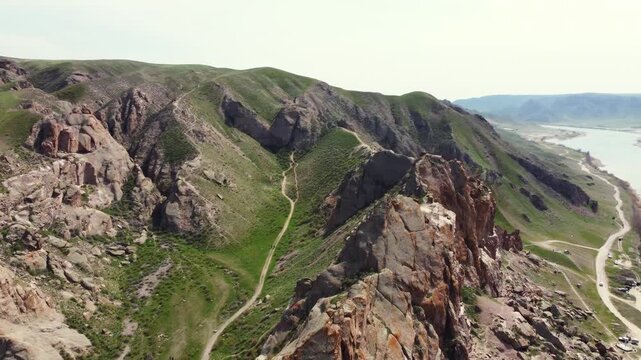 Aerial 4K view of Ili River and sacred Tamgaly Tas petroglyphs in Kazakhstan steppe