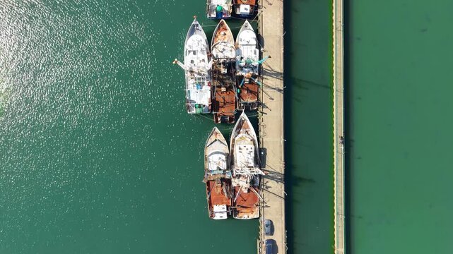 Aerial view of commercial fishing trawlers and scalloping boats docked at a concrete pier in Newport News, Virginia