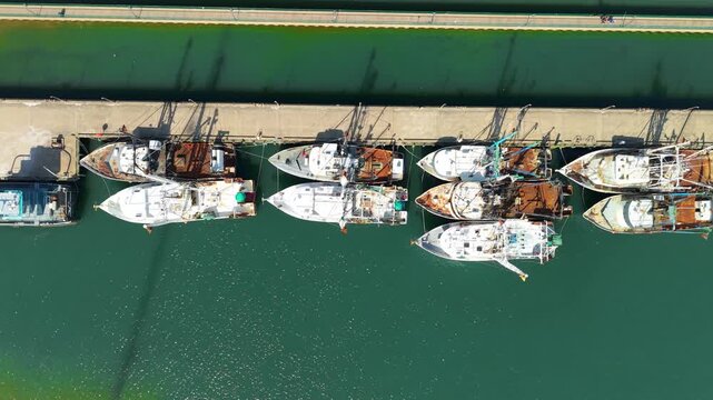 Aerial view of commercial fishing trawlers and scalloping boats docked at a concrete pier in Newport News, Virginia