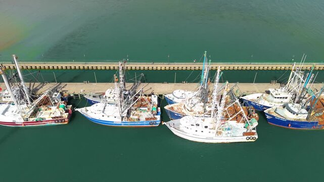 Aerial view of commercial fishing trawlers and scalloping boats docked at a concrete pier in Newport News, Virginia