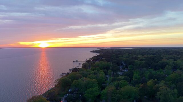 James River coastline in Newport News, Virginia, aerial sunset video, featuring luxury waterfront residential homes and a vibrant evening sky. 