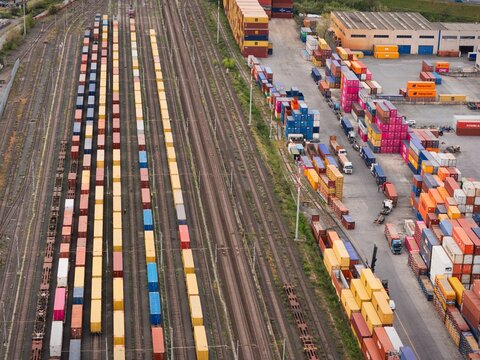 Santo Stefano di Magra, Italy - 18 April 2026: Aerial view of the Retroporto merci freight terminal with colorful shipping containers on railway tracks and stacked in the logistics area.