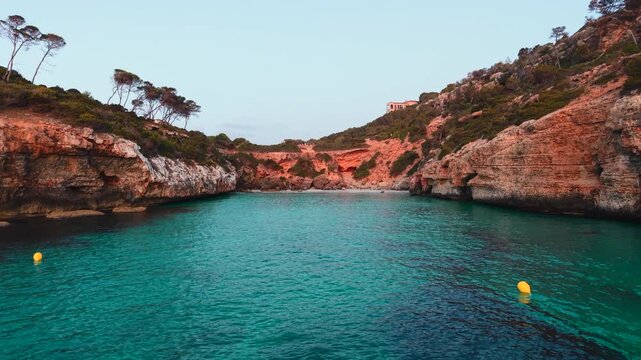 Calo des moro beach showcases turquoise water, a rocky coastline, and lush greenery