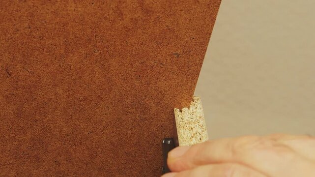 A person assembles furniture with drawers by hand. Medium shot.