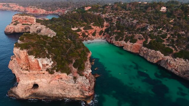 Calo des moro beach, with turquoise water and white sand, surrounded by cliffs and vegetation, in majorca, spain