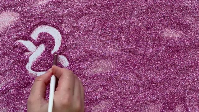 The numbers "2027" painted on shiny pink glitter. Perfect for year-themed projects, calendars, or New Year's celebrations. Symbolizes planning for the future or counting down.