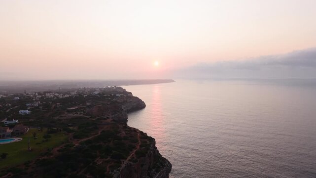 Warm sunlight bathes the cliffs and ocean near calo des moro, algarve, portugal