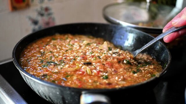 Authentic Preparation of Greek Gemista: Traditional Stuffed Peppers with Herbed Rice, Tomato Sauce, and Fresh Vegetables in a Kitchen Setting