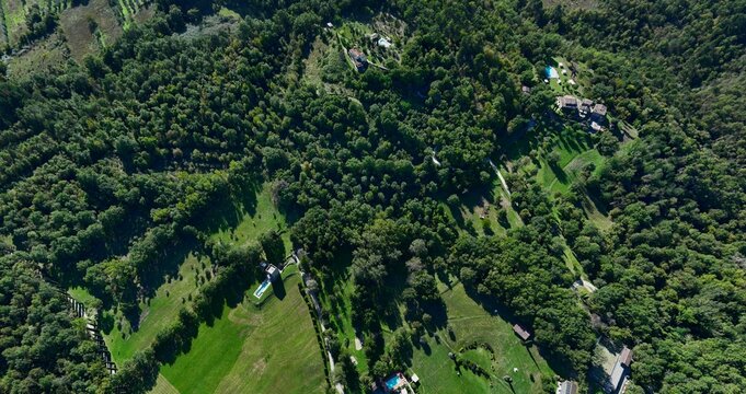 Poppi, Italy - 17 April 2026: Aerial view of Fattorie di Celli resort surrounded by dense green forests, swimming pools, and rolling hills in the Tuscan countryside.
