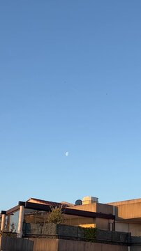 Dusk Sky: A captivating image capturing the tranquility of a dusk sky, with buildings below and the moon.