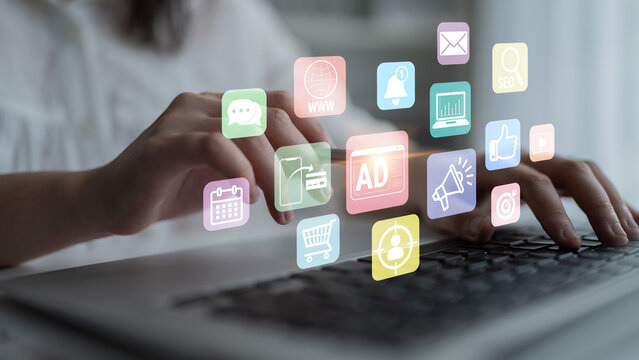 Hands Typing on Laptop Keyboard Surrounded by Colorful Digital Icons Representing Technology, Communication, Marketing, and Business Concepts Fluxor.